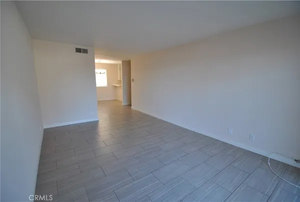 an empty room with windows and ceiling fan