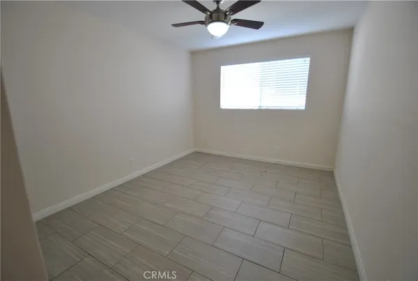 an empty room with closet and a ceiling fan