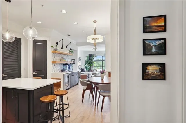 a dining room with furniture a chandelier and kitchen view