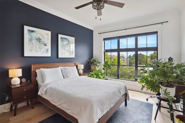 a bedroom with a large bed and a potted plant