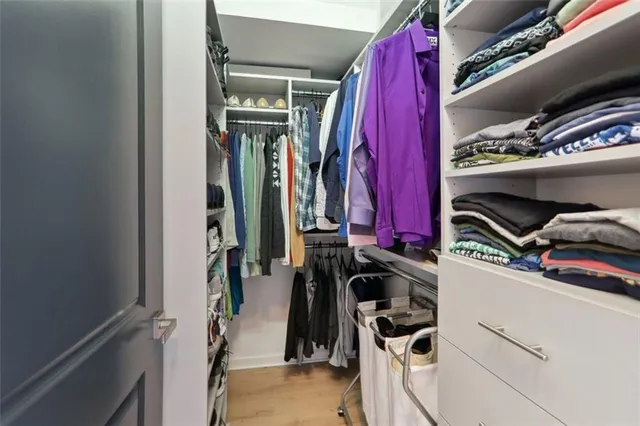 a view of walk in closet with clothes