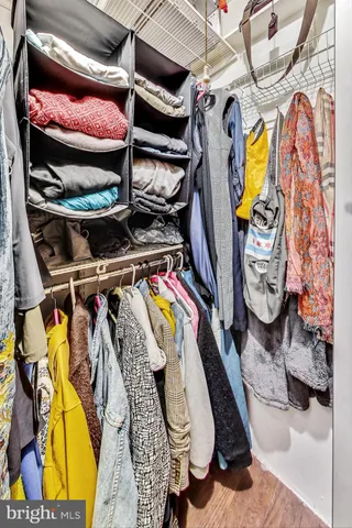 a view of walk in closet with clothes and shoes