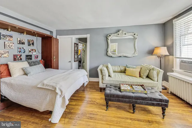 a spacious bedroom with a bed and wooden floor