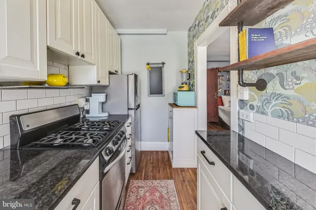 a kitchen with stainless steel appliances granite countertop a stove and a sink
