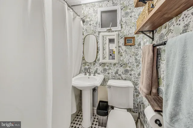 a bathroom with a sink toilet and mirror