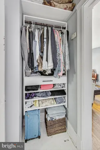 a view of walk in closet with clothes and shoes