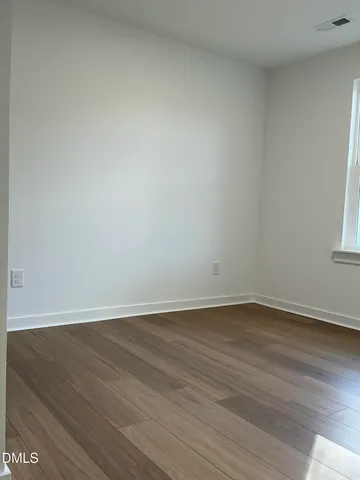 a view of an empty room and wooden floor