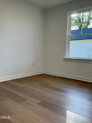 a view of a small space with wooden floor and a window