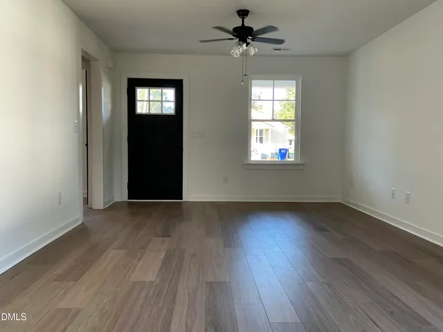 a view of an empty room window and wooden floor