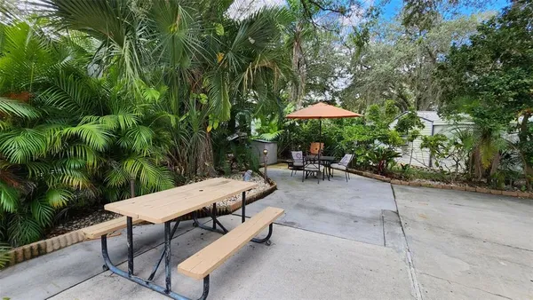 a view of a patio with a table and chairs under an umbrella