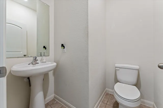 a bathroom with a toilet a sink and mirror