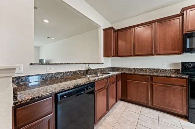 a kitchen with granite countertop cabinets sink and stove