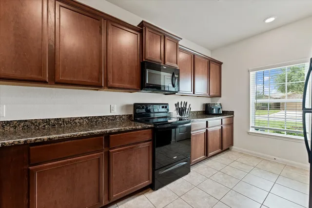 a kitchen with stainless steel appliances granite countertop wooden cabinets a stove top oven a sink and dishwasher