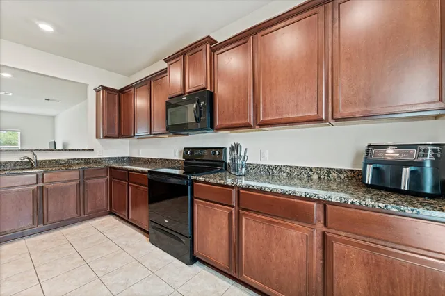 a kitchen with stainless steel appliances granite countertop a sink stove and microwave