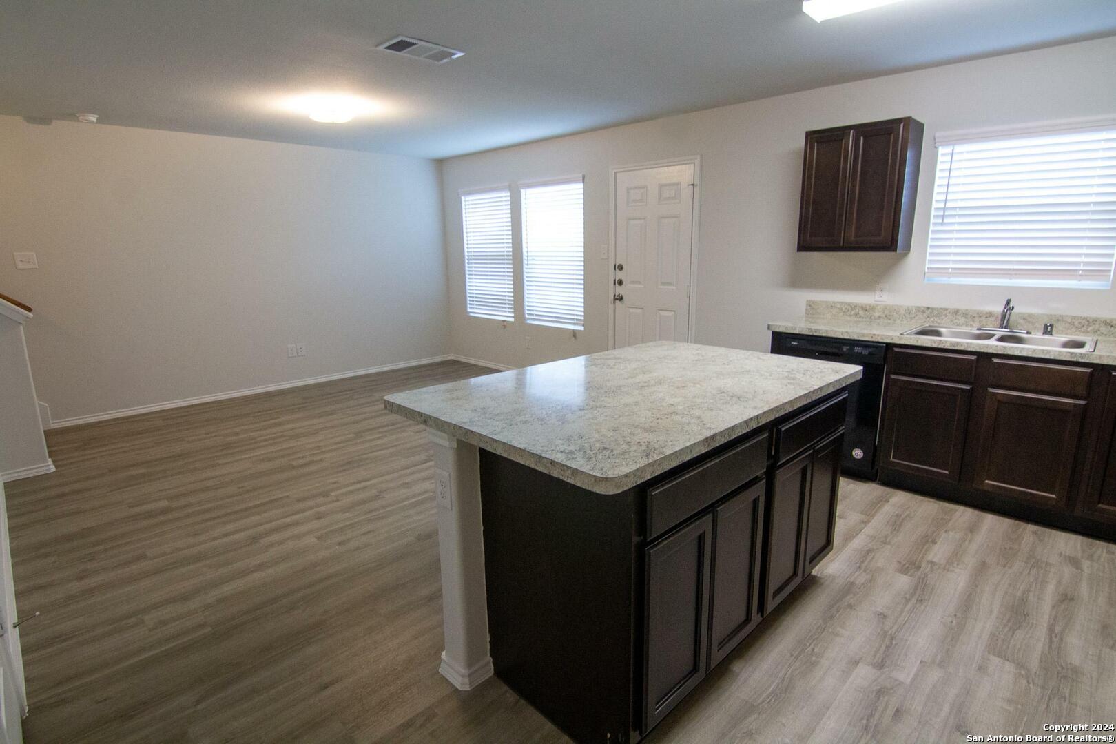 10706 Apple Pie Road San Antonio, TX 78224 - Photo 5 of 14 a kitchen with granite countertop sink stove and cabinets