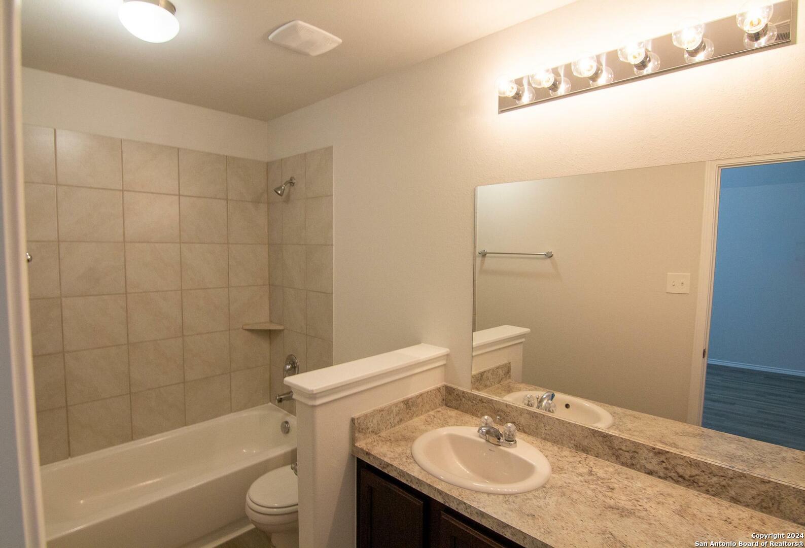 10706 Apple Pie Road San Antonio, TX 78224 - Photo 9 of 14 a bathroom with a sink a toilet and shower