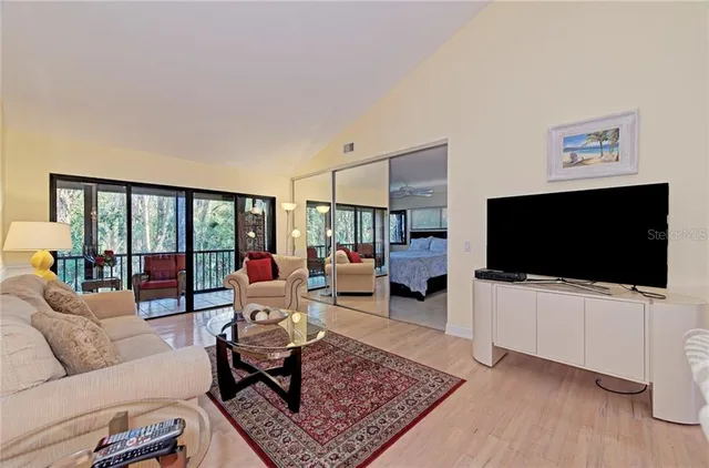 a living room with furniture a flat screen tv and a rug