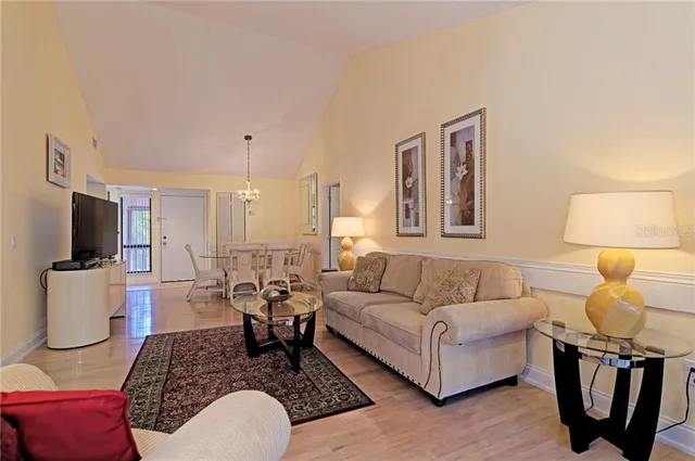 a view of a dining room with furniture a chandelier and wooden floor