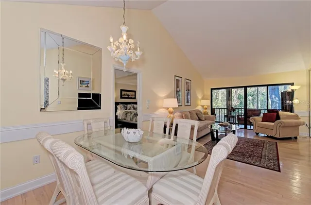 a living room with furniture a flat screen tv and a dining table with wooden floor