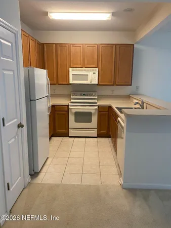 a kitchen with a refrigerator sink and cabinets