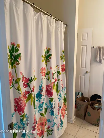 a bathroom with a granite countertop a sink a mirror and a shower curtain