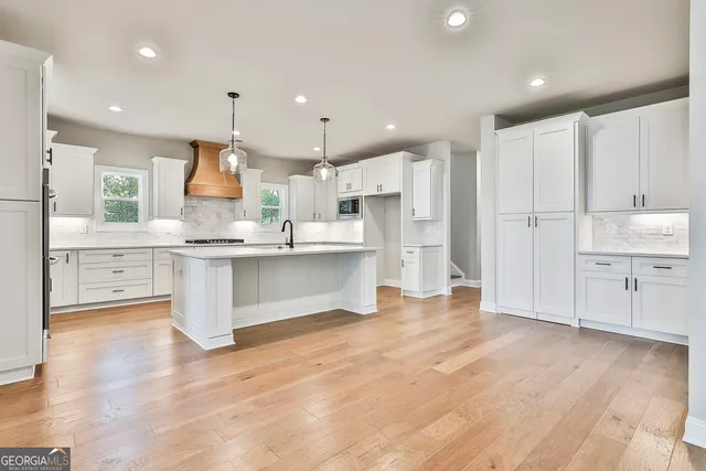 a large kitchen with cabinets and wooden floor