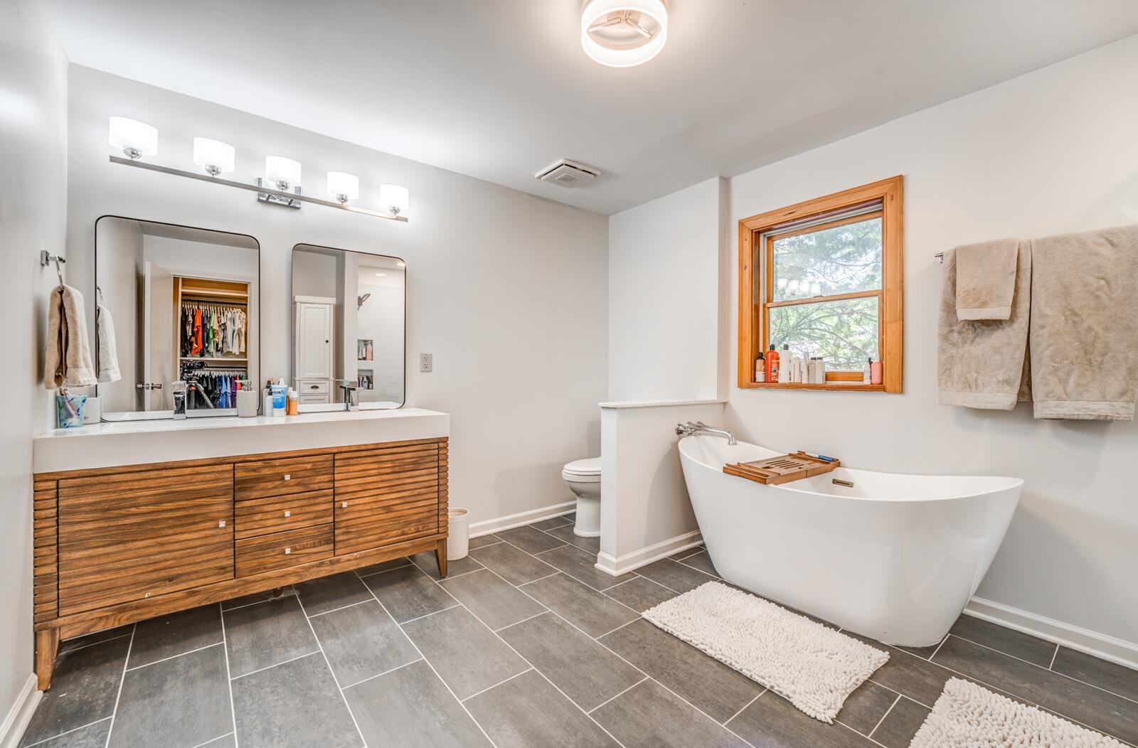 8651 Baylor Road Bartlett, TN 38002 - Photo 10 of 29 a spacious bathroom with a double vanity sink a mirror a bathtub and a window