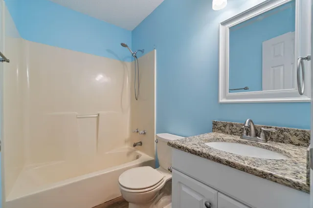 an empty room with closet and a ceiling fan