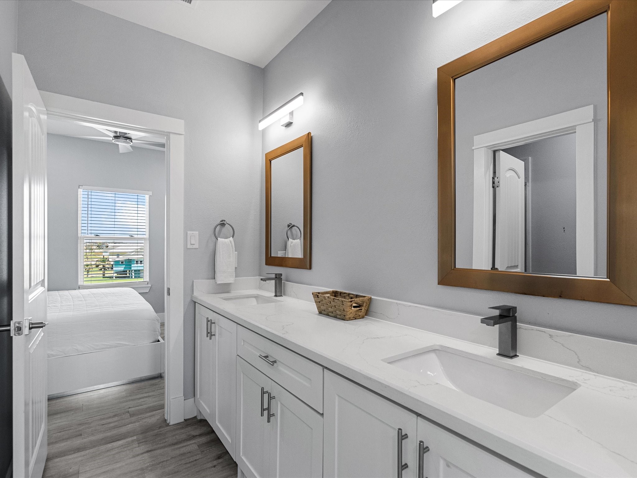 718 Beach Drive Surfside Beach, TX 77541 - Photo 32 of 49 This bright bedroom boasts a modern ceiling fan, spacious double-door closet, and an en-suite bathroom. A large window fills the space with natural light, complemented by a stylish mustard-yellow chair.