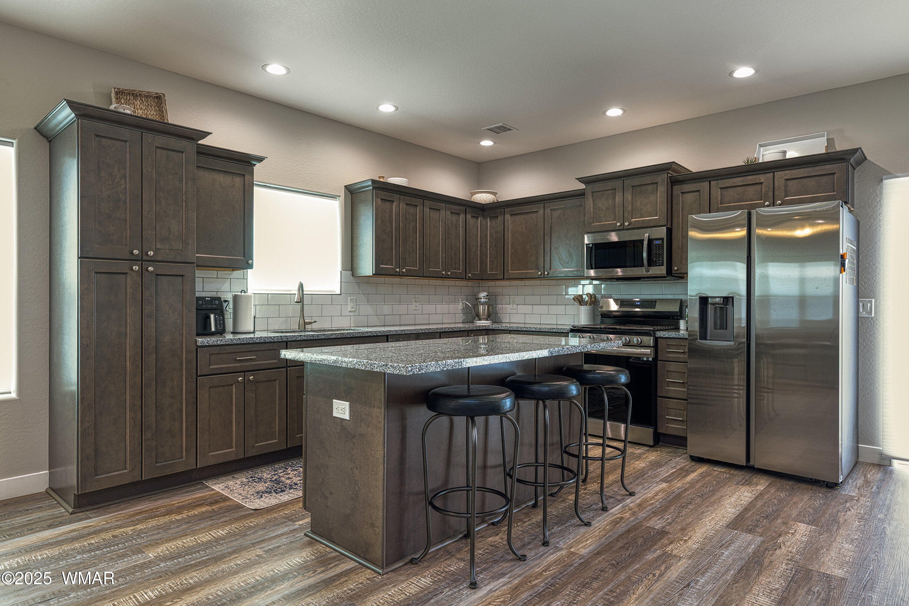 799 Cobble Lane Taylor, AZ 85939 - Photo 8 of 34 a kitchen with kitchen island granite countertop stainless steel appliances and wooden cabinets