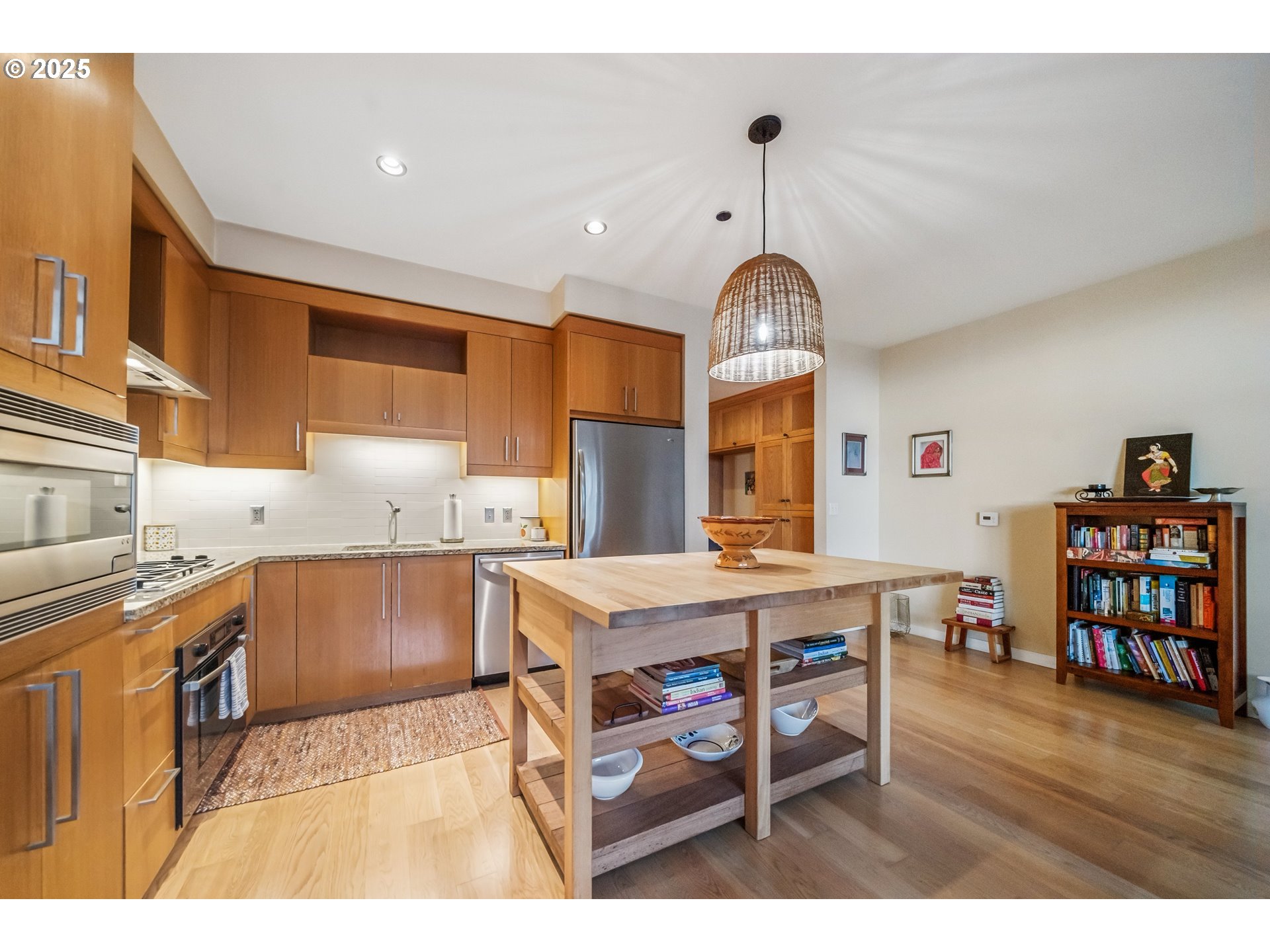 2351 Northwest Westover Road, Unit 315 Portland, OR 97210 - Photo 5 of 16 a kitchen with stainless steel appliances granite countertop a stove oven a dining table and chairs with wooden floor