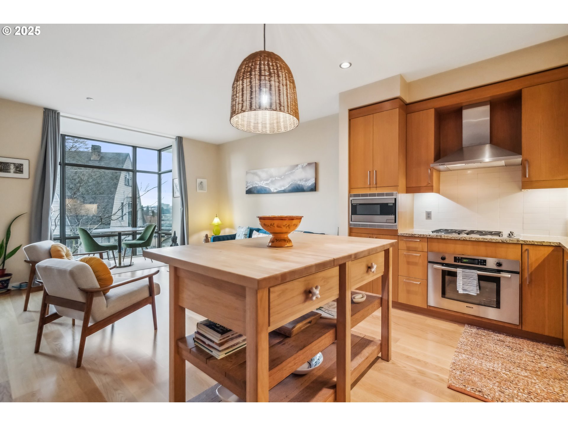 2351 Northwest Westover Road, Unit 315 Portland, OR 97210 - Photo 7 of 16 a kitchen with a stove a sink dishwasher a dining table and chairs with wooden floor