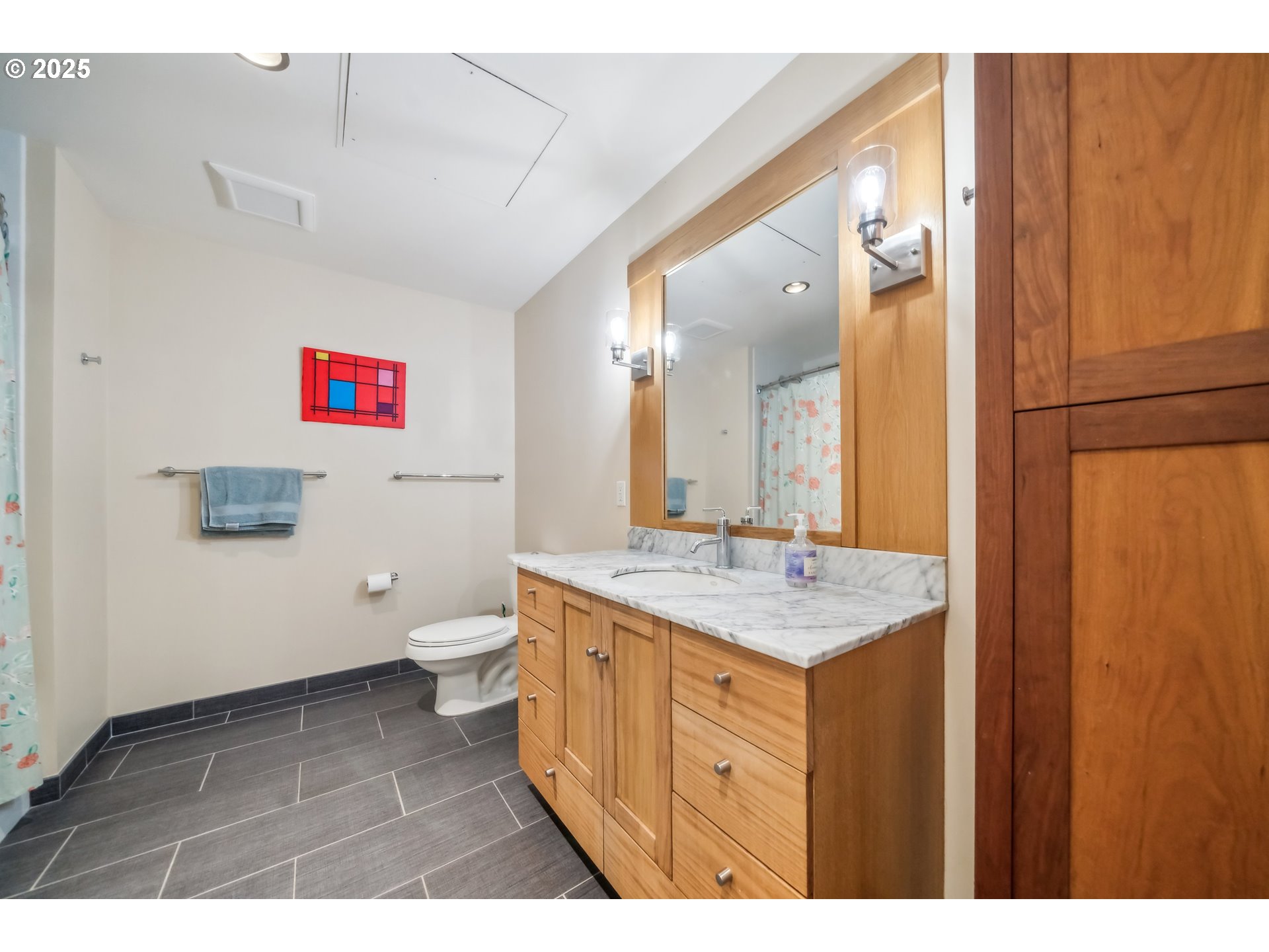 2351 Northwest Westover Road, Unit 315 Portland, OR 97210 - Photo 8 of 16 a bathroom with a granite countertop sink a toilet and a mirror