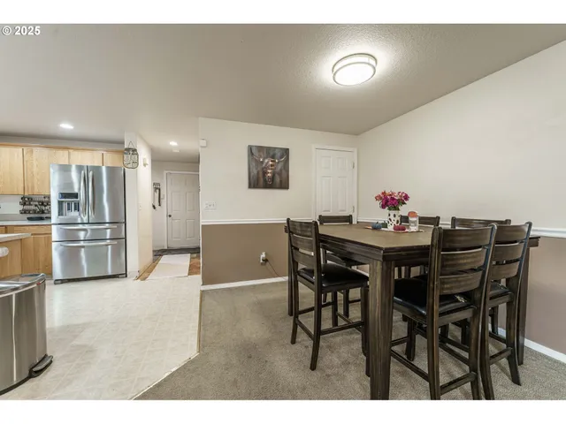 a view of a dining room with furniture and kitchen view