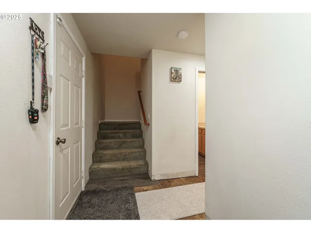 a view of a hallway with wooden floor and entryway