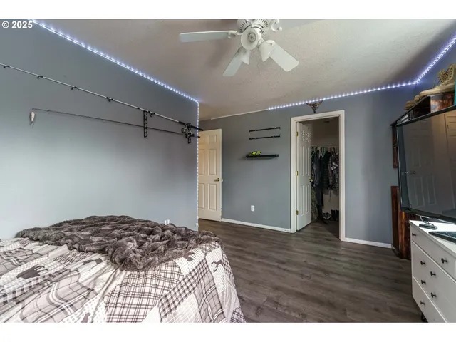a bedroom with a bed and a flat tv screen on dresser