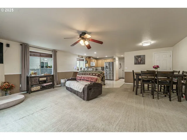 a living room with furniture and a dining table with wooden floor