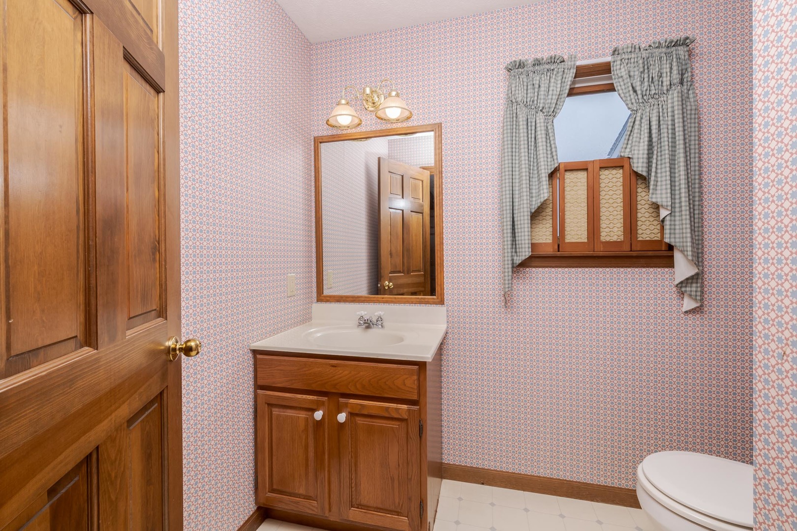 1402 East Indiana Avenue Pontiac, IL 61764 - Photo 22 of 54 a bathroom with a toilet sink vanity and mirror