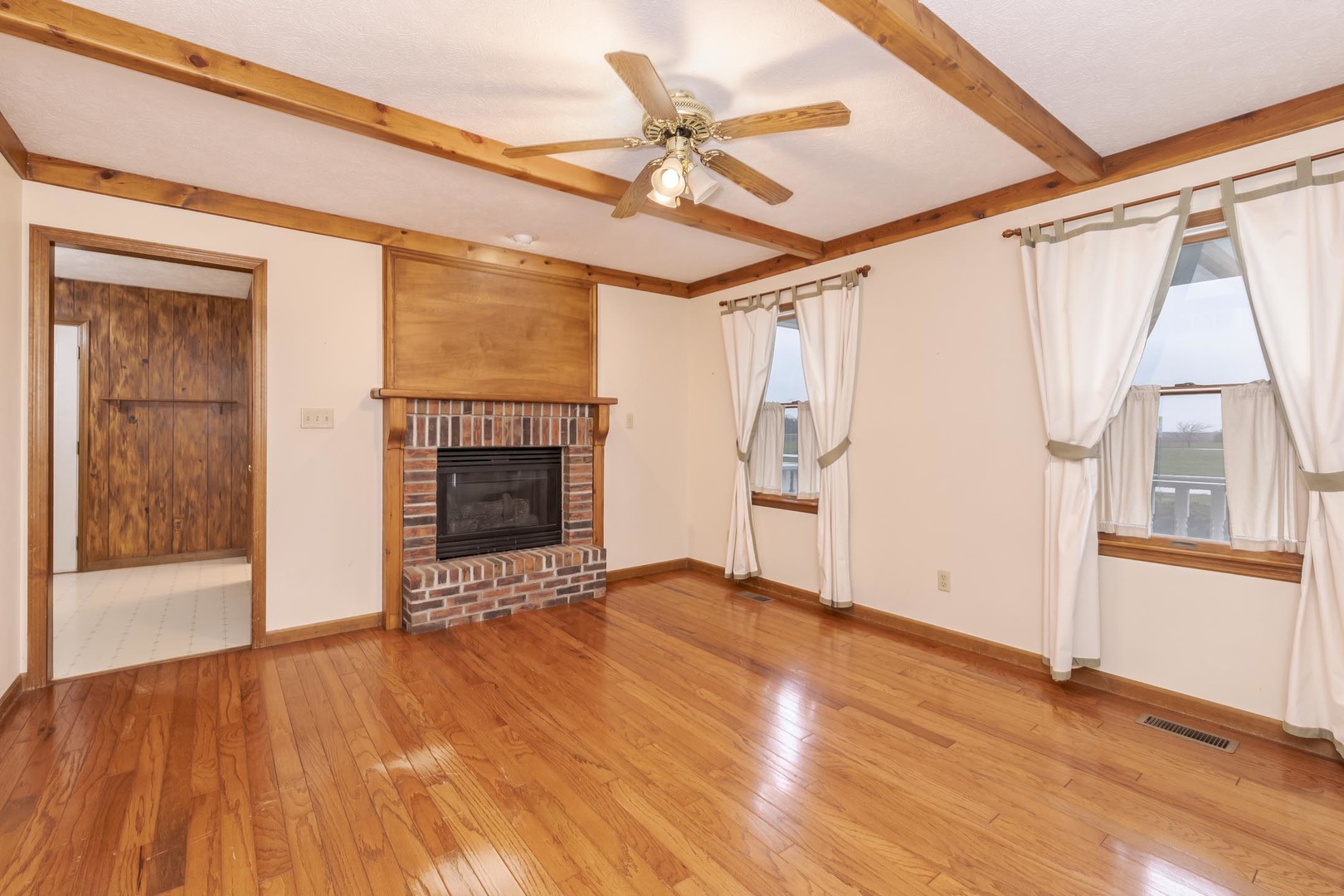 1402 East Indiana Avenue Pontiac, IL 61764 - Photo 6 of 54 a view of an empty room with wooden floor and a fireplace