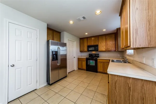 a kitchen with a sink a counter top space and stainless steel appliances