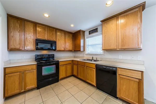 a kitchen with stainless steel appliances granite countertop wooden cabinets a stove top oven a sink and dishwasher