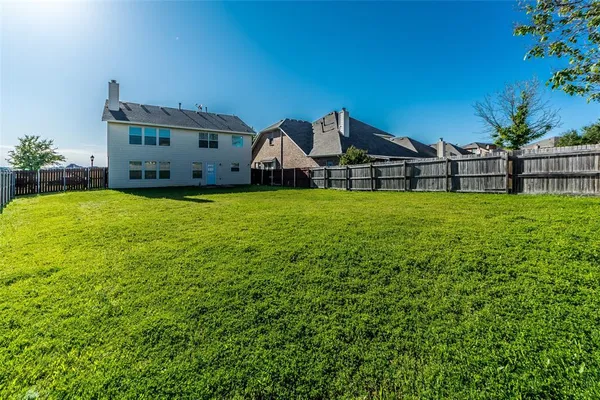 a house with green field in front of it