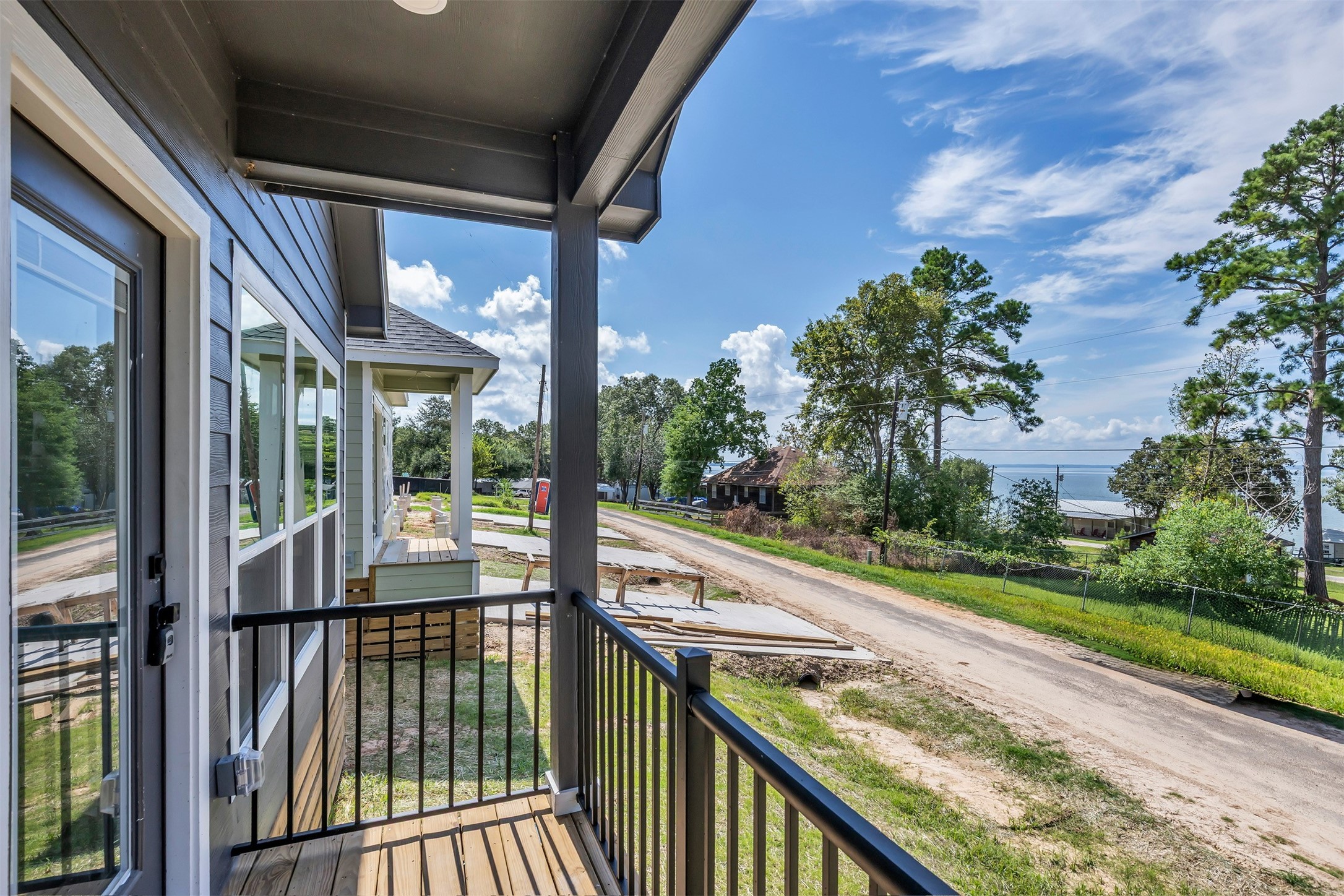 117 Rain Forest Road Onalaska, TX 77360 - Photo 7 of 30 Enjoy serene views from this charming porch, featuring modern railing and surrounded by lush greenery and a peaceful neighborhood.