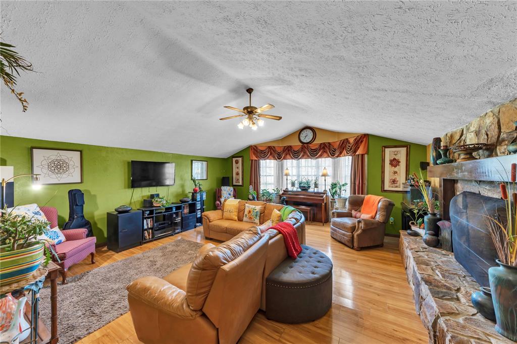 13610 Acker Road Dover, FL 33527 - Photo 36 of 53 a living room with furniture a fireplace and a flat screen tv