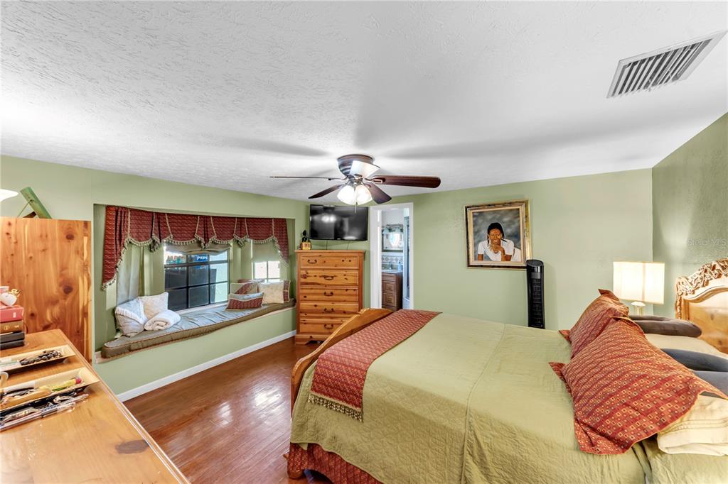 13610 Acker Road Dover, FL 33527 - Photo 47 of 53 a bedroom with a large bed and a chandelier