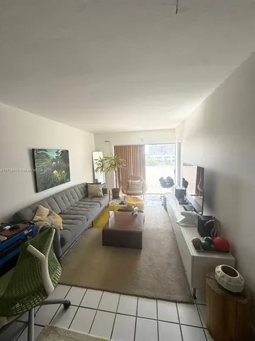 a living room with lots of furniture and kitchen view