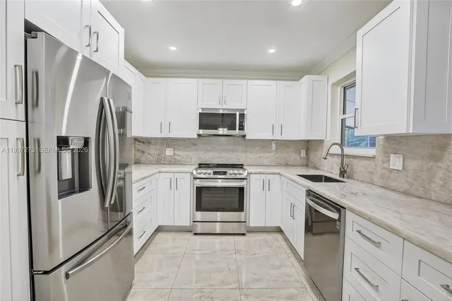 a kitchen with stainless steel appliances granite countertop a refrigerator stove and sink