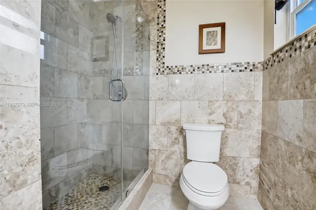 a white toilet sitting next to a bathroom sink