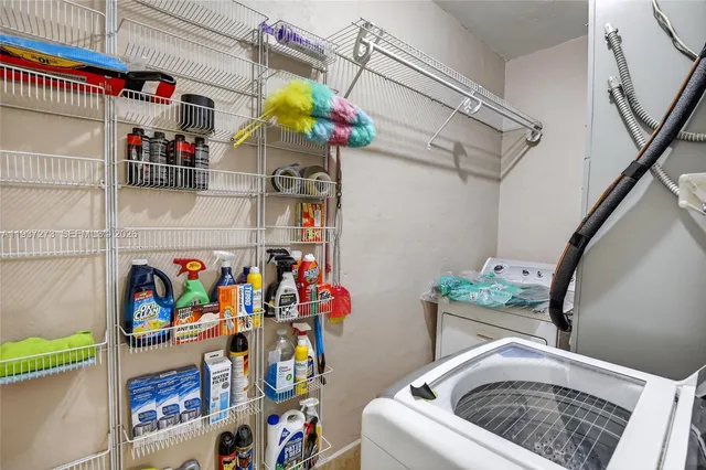 a utility room with fridge dryer and washer