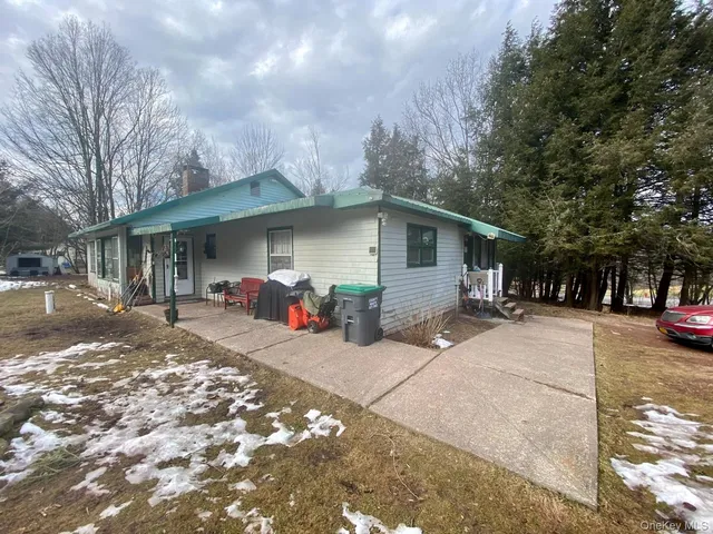 a front view of a house with a yard and trees